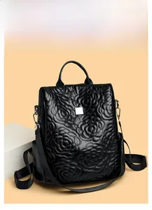 Détail d'un sac à dos en cuir noir avec texture florale 3D et poches latérales