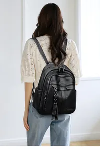 Close-up of black lychee grain leather backpack with fringe zippers on female model