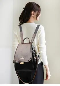 Close-up of leather backpack with kangaroo logo and classic red-green striped webbing