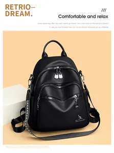 Detail view of black lychee grain leather backpack with metallic logo and multi-zipper layers