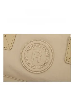 Detail of round rubber brand logo patch on durable nylon fabric of waterproof backpack