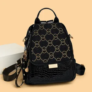 Punk style black backpack with crocodile texture, gold rivets, and starry diamond accents