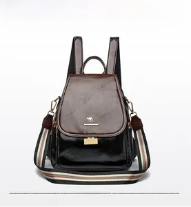 Detail of premium brown leather flap and colorful striped strap on a versatile backpack