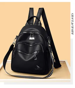 Detail of black embroidered leather backpack showing metal kangaroo logo and zippers