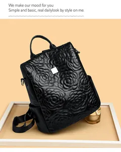 Détail d'un sac à dos en cuir matelassé avec motif floral et plaque logo argentée