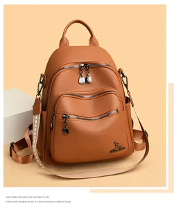 Detail of brown litchi grain leather backpack with embroidered ethnic style wide strap
