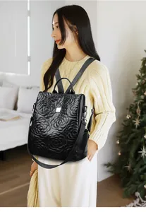 Détail du sac à dos en cuir noir avec matelassage rose 3D et ornements argentés