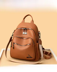 Macro detail of brown litchi pattern leather backpack with three front zipper pockets