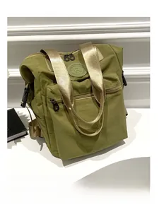 Detail of olive green waterproof nylon backpack with champagne gold handles and round logo