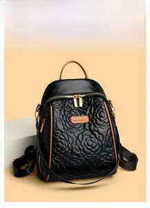 Dettaglio dei motivi floreali a rilievo sullo zaino in pelle PU nera con zip dorata
