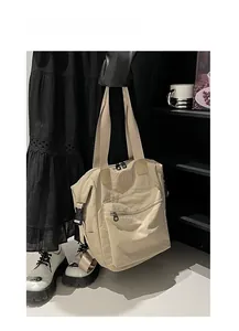 Detail of beige waterproof nylon backpack featuring round logo and front zip pocket