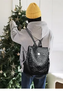 Détail du sac à dos noir en cuir PU avec surpiqûres florales et boucle métallique chic