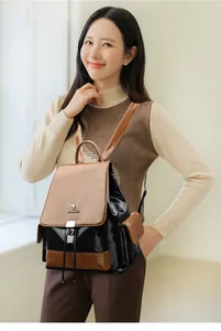 Detail of drawstring leather backpack featuring metal buckle and side pocket on model
