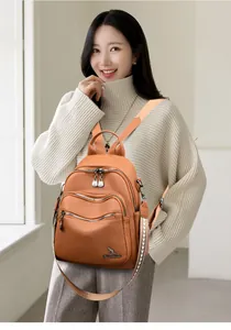 Detailed view of an orange-brown textured leather backpack with a kangaroo brand logo
