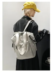 Minimalist white nylon backpack featuring multiple zip compartments and branded round logo