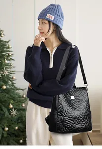 Détail du sac à dos matelassé avec fleurs gaufrées et poche latérale en cuir noir