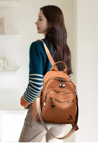 Detail of a brown lychee pattern leather backpack featuring a patterned wide shoulder strap