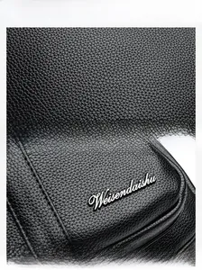 Macro view of black lychee grain leather texture and metallic Weisendaishu brand logo