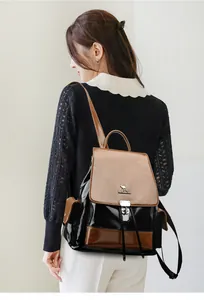 Detail of a color-block leather backpack featuring silver kangaroo logo and dual tassels