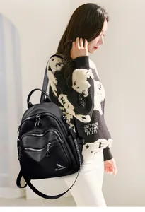 Detailed view of a black leather backpack for women featuring multiple zipper pockets