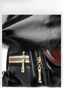Detailed macro view of black glossy leather texture and golden zipper with striped ribbon