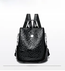Vue de face du sac à dos en cuir noir avec motifs floraux en 3D et poignée supérieure