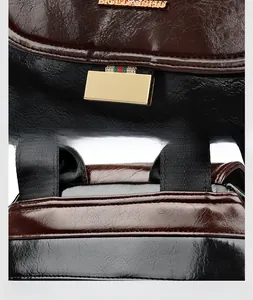 Close-up of golden metal lock and precision stitching on dark brown leather backpack