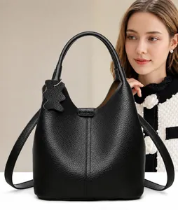 Détail du sac seau en cuir grainé noir avec charme d'ours et bandoulière amovible
