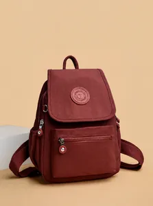 Detalle de mochila de nailon rojo oscuro con tirador de cremallera metálico de calidad
