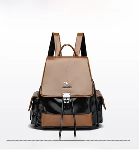 Detail shot of the two-tone leather backpack featuring a drawstring and metal buckle closure