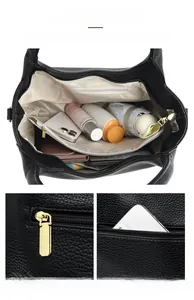 Detail of black pebbled leather tote showing spacious interior compartments and gold zippers