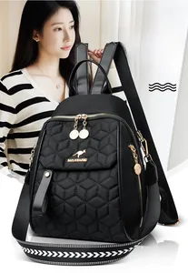 Detail of black quilted backpack featuring golden kangaroo logo and metal zip pendants
