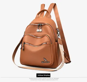 Detail of a brown leather multi-functional backpack with embroidery and gold hardware