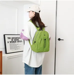 Waterbestendige felgroene nylon rugzak gedragen door model voor een casual alledaagse stijl