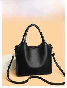 Close-up of black litchi pattern leather handbag featuring kangaroo logo and dual ring handles