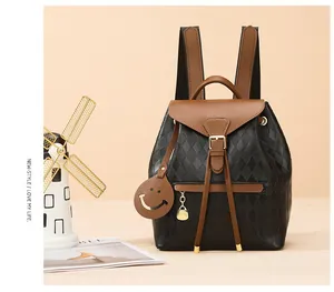 Détails du sac à dos matelassé noir avec cuir marron, cordon de serrage et breloque
