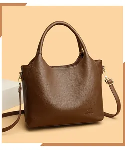 Detail of dark brown pebble leather tote bag featuring gold hardware and adjustable strap