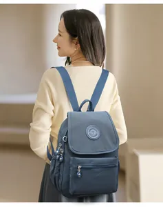 Detalle de mochila azul marino impermeable con logo y cremalleras de metal plateado