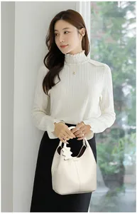 Chic beige pebbled leather bucket bag styled with an elegant lace top and skirt
