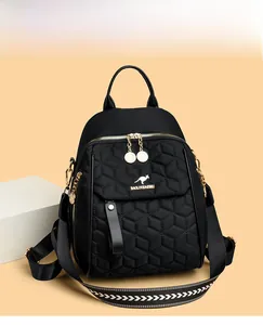 Detail of black quilted backpack featuring gold kangaroo logo and textured woven straps