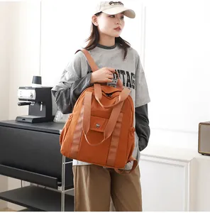 Details des dunkelorangefarbenen wasserfesten Nylon-Rucksacks mit Magnetklappe und Taschen