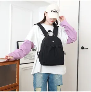 Lifestyle foto van een kleine zwarte nylon rugzak met trekkoordvak gedragen door een model