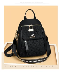 Close-up of black quilted backpack with kangaroo gold logo and woven pattern strap