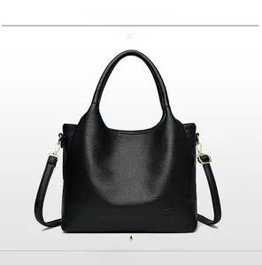 Detailed front view of black pebbled leather tote bag with handles and adjustable shoulder strap