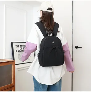 Achteraanzicht van model met een zwarte waterbestendige nylon rugzak met trekkoord sluiting