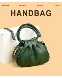Détail d'un sac à main plissé vert foncé montrant la texture cuir et le zip en métal doré