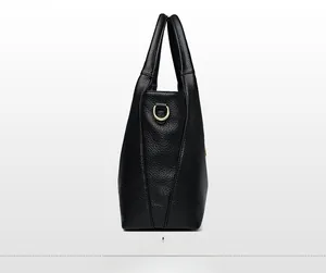 Close-up of black lychee leather tote bag with gold D-ring and detailed stitching