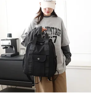 Detail eines schwarzen wasserdichten Nylon-Rucksacks mit Seitentaschen und Ledergriff