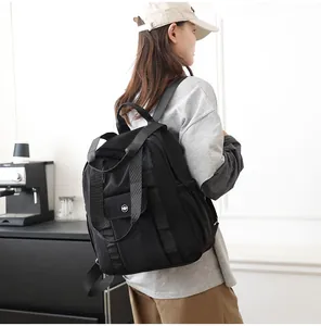 Wasserdichter schwarzer Nylonrucksack für Damen an einem Model in einem Raum