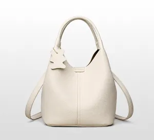 Détail du sac seau en cuir grainé blanc cassé avec un charmant pendentif en forme d'ours